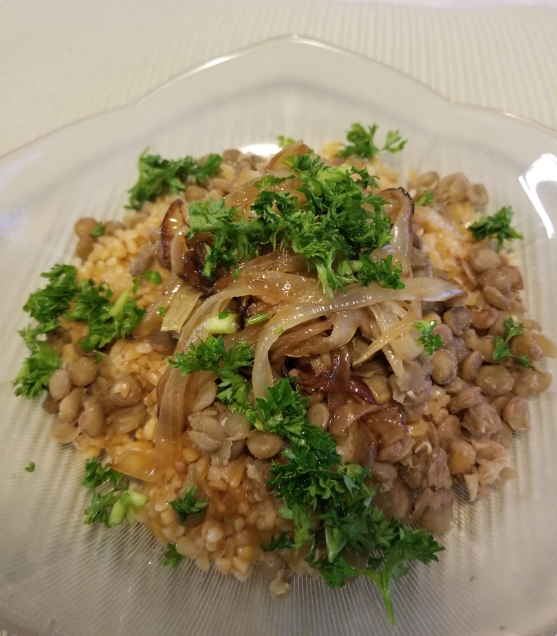 mjadarah a Mediterranean bulgur main dish made of bulgur, lentils, fried onions and garnished with parsley